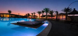 a large swimming pool with umbrellas and palm trees at Sunset Agafay Resort in El Karia +22 photos