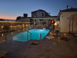 ein Swimmingpool in einem Garten bei Nacht in der Unterkunft Koukounari Apartments in Skala + 40 Fotos