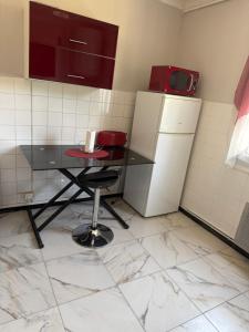 a small kitchen with a table and a refrigerator at Chez Séverine in Avignon