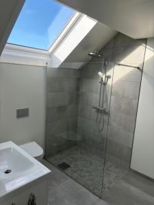 a bathroom with a shower and a skylight at Central apartment for ONS in Stavanger