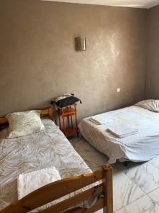 a bedroom with two beds and a chair in it at Chez Séverine in Avignon