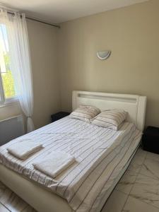 a white bed with towels on it in a bedroom at Chez Séverine in Avignon