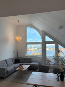 a living room with a couch and a large window at Central apartment for ONS in Stavanger