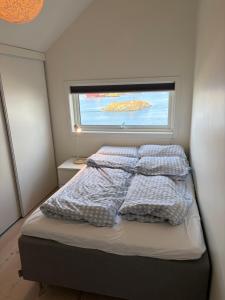 a bedroom with a bed with pillows and a window at Central apartment for ONS in Stavanger