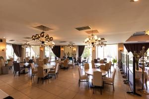 ein Esszimmer mit Tischen, Stühlen und Kronleuchtern in der Unterkunft Amalias Hotel in Kourouta