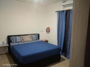 a small bedroom with a blue bed and blue curtains at L'Urbain in Ziguinchor