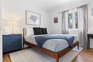 a bedroom with a bed with a blue dresser and a window at Spacious House with Modern Comforts and Nature in Cushing