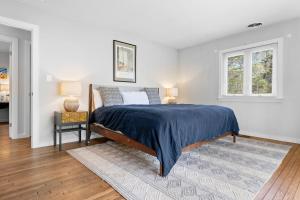 a bedroom with a bed and two windows at Spacious House with Modern Comforts and Nature in Cushing
