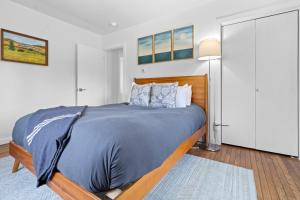 a bedroom with a large bed with a blue blanket at Spacious House with Modern Comforts and Nature in Cushing