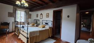 a bedroom with a bed with a wrought iron bed frame at Casa Vixide in Lalín