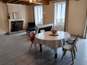 a living room with a table and chairs and a fireplace at Maison in Reignac