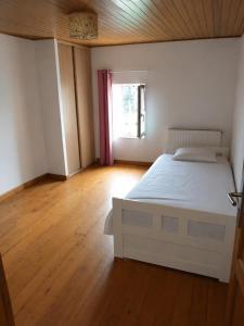 a bedroom with a white bed and a window at Maison in Reignac