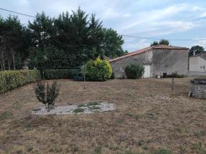 a yard with a stone building and a tree at Maison in Reignac