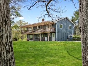 a blue house with a deck on top of a yard at Spacious House with Modern Comforts and Nature in Cushing +34 photos
