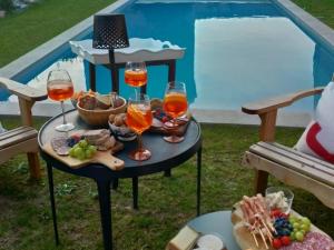 a table with glasses of wine and food on it at Le Clos de l'Aiguillon in Hérouvillette