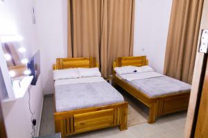 two beds in a small room withermottermott at Mwisongo Homestay in Morogoro