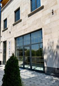 a building with glass doors on the side of it at WHITE HOTEL GYUMRI in Gyumri