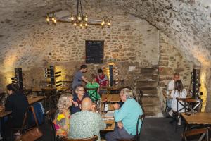 a group of people sitting at tables in a restaurant at Au Château de Villelongue B&B in Villelongue-dʼAude