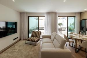 a living room with a couch and a dining room at The Downtown Largo do Carmo in Faro