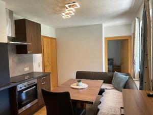 a kitchen and living room with a table and a couch at Haus Deutschmann in Wenns +7 photos