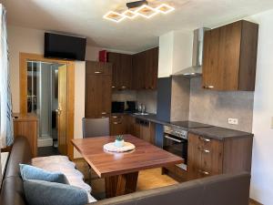 a kitchen with wooden cabinets and a wooden table at Haus Deutschmann in Wenns