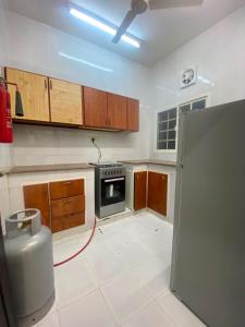 a kitchen with a stove and a refrigerator at الفردوس - RED14 Al-Firdous in Salalah +20 photos