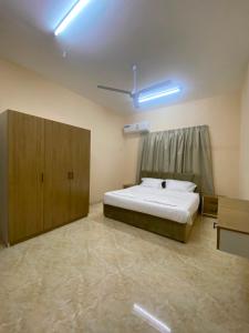 a bedroom with a large bed and cabinets in it at الفردوس - RED14 Al-Firdous in Salalah