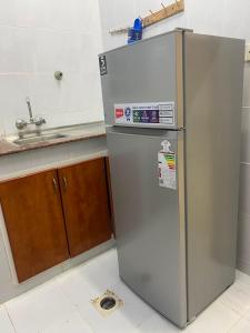 a silver refrigerator in a kitchen next to a sink at الفردوس - RED14 Al-Firdous in Salalah