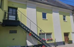 a yellow and green building with a staircase on it at Apartment MICHAELA in Spital am Pyhrn