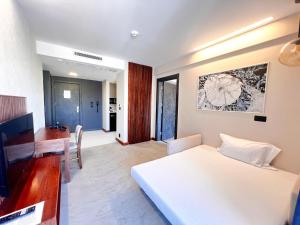 a bedroom with a white bed and a dining room at ERTAN OTEL in Çeşme