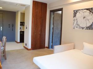 a bedroom with a white bed and a wooden door at ERTAN OTEL in Çeşme