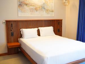 a bedroom with a large bed with a wooden headboard at ERTAN OTEL in Çeşme +77 photos