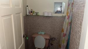 a bathroom with a toilet with a shelf above it at The Doctor's Quarters DQ in San Fernando