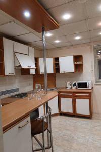a kitchen with white cabinets and a wooden counter top at Fortuna hostel in Odesa