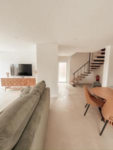a living room with a large couch and a table at PiuPiuStays in Vermelho