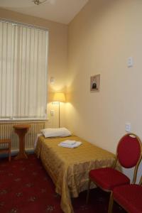 a hotel room with a bed and two chairs and a window at Fortuna hostel in Odesa