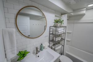 a white bathroom with a mirror and a sink at Modern Basement Apartment King Bed and Full Kitchen in Bluffdale