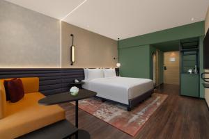 a hotel room with a bed and a couch at Novotel Bhubaneswar Janpath in Bhubaneshwar +26 photos