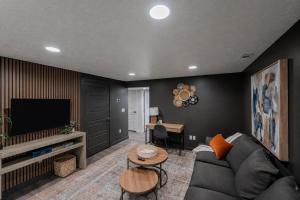 a living room with a couch and a television at Modern Basement Apartment King Bed and Full Kitchen in Bluffdale