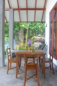 a wooden table with two chairs and a table at Rock Harmony Villa in Dodanduwa