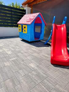 a toy dog house and a slide on a patio at CAZARE TURISM PRISLOP in Haţeg