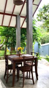 a wooden table and chairs on a patio at Rock Harmony Villa in Dodanduwa +26 photos