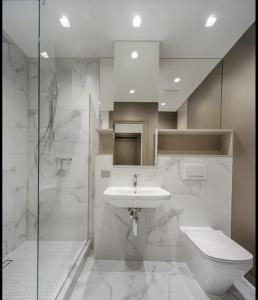 a bathroom with a sink and a toilet and a shower at The Roaring Pines in Dhikuli