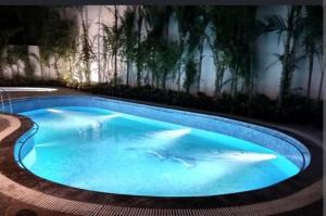 a large blue swimming pool with trees in the background at The Roaring Pines in Dhikuli +18 photos
