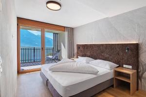 a bedroom with a large bed and a balcony at Residence Froy in Resia