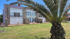 a palm tree in front of a house at La Morada del CABO PEÑAS Folu - Gozón - Luanco in Ferrero