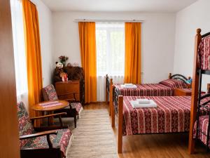 a hotel room with two beds and a chair at Pottery House Sanahin in Alaverdi