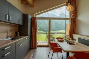 a kitchen with a table and a large window at Unterbergerhof - Escape daily life - Enjoy nature - Explore more with activeCARD Sterzing in Val di Vizze