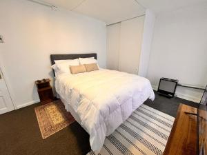 a bedroom with a large bed with white sheets and pillows at The White House Hostel in Puerto Natales +6 photos