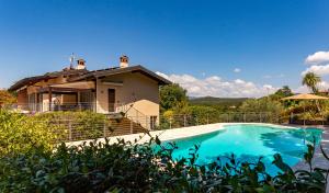 a villa with a swimming pool in front of a house at Sunset Serenity Villa in Padenghe sul Garda